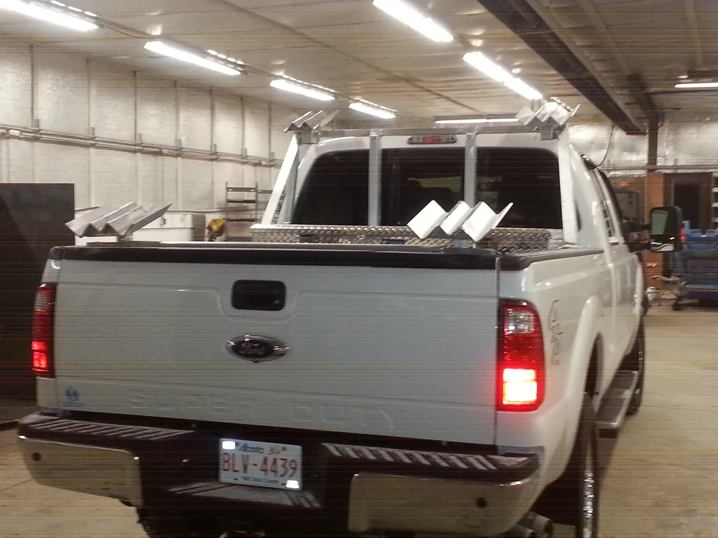 A white truck with two racks on the back of it.